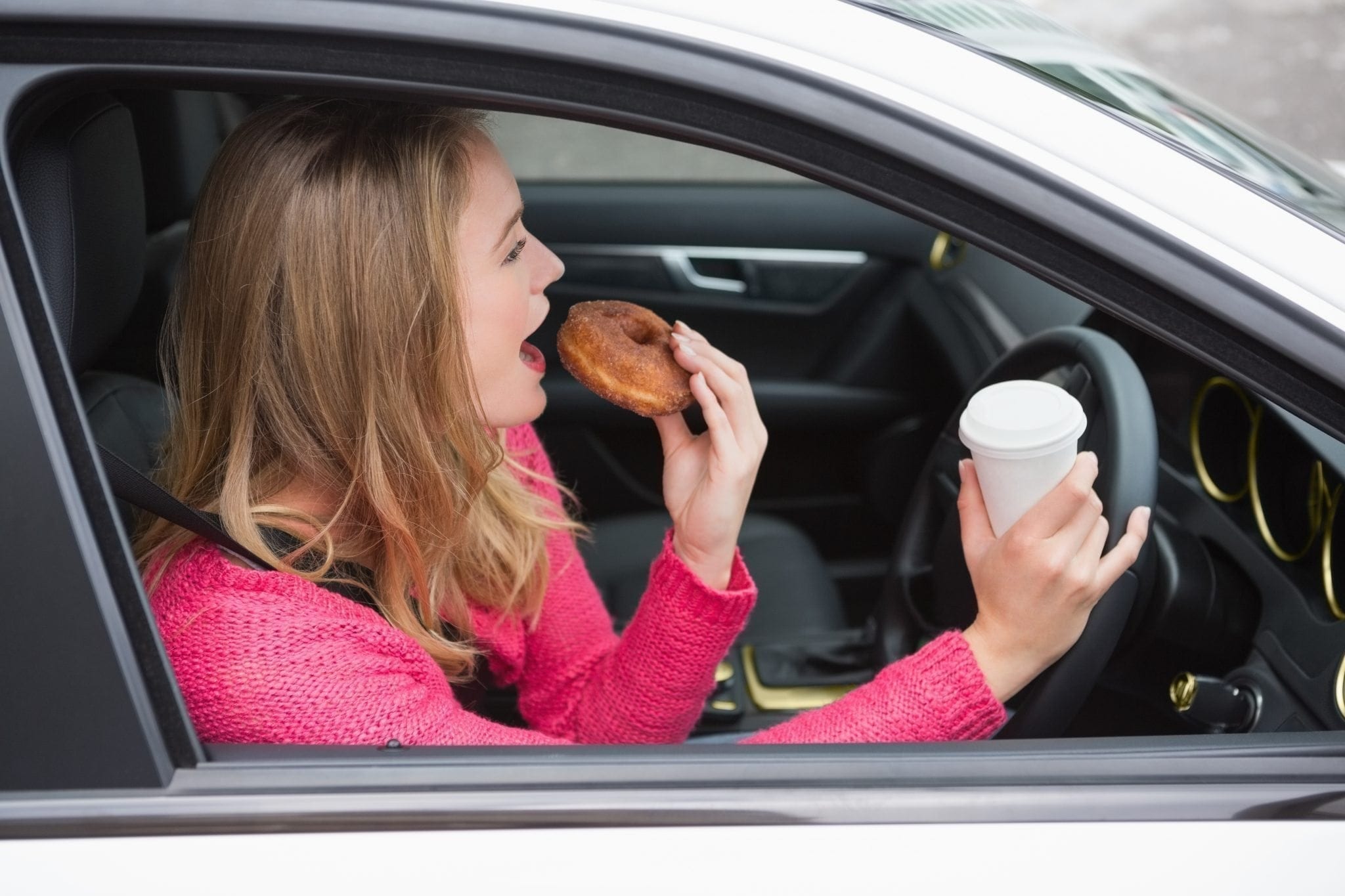 eating donut while driving