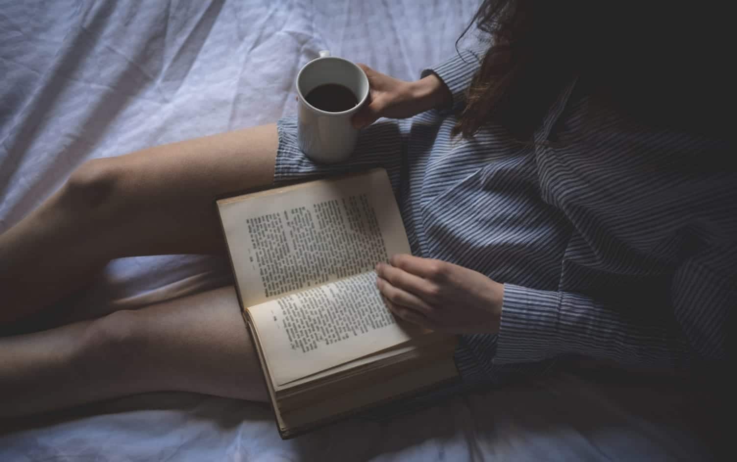 Девушка читает книгу на кровати