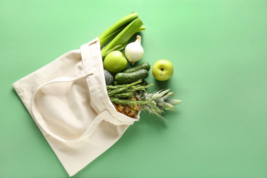 Fresh green vegetables in a beige canvass bag